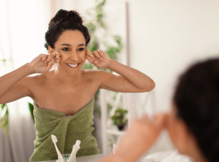 Giovane donna massaggia il suo viso